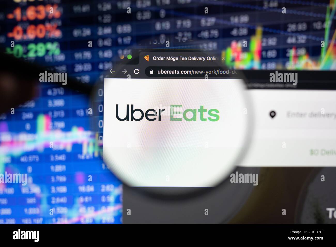 Uber Eats company logo on a website with blurry stock market 