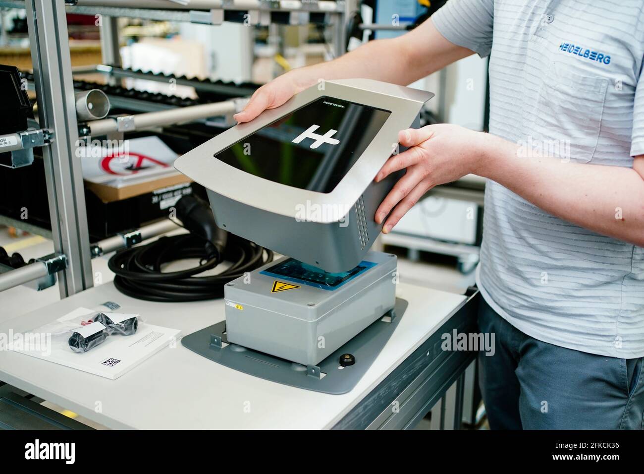 Wiesloch, Germany. 28th Apr, 2021. An employee assembles a "Wallbox Energy  Control" type charger at the main plant of Heidelberger Druckmaschinen AG.  The devices take care of load distribution when charging up