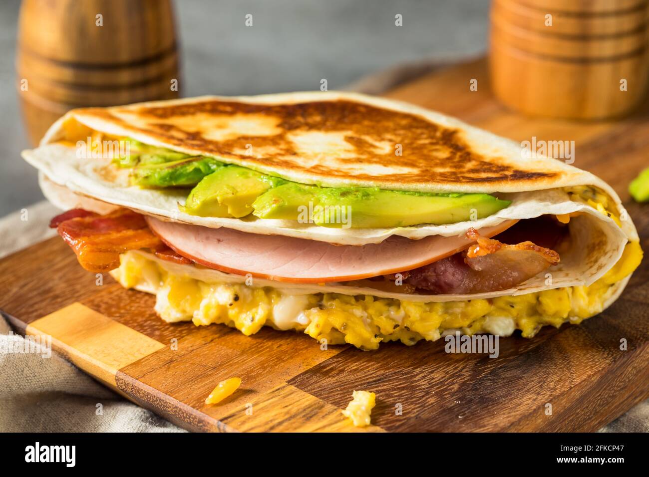 Homemade Trendy Egg Tortilla Breakfast Sandwich with Ham and Avocado Stock Photo