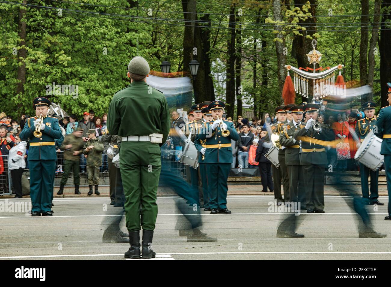 military holiday in city, parade of armed forces of country a solemn March through streets of city, soldiers in uniform clearly stamping step in colum Stock Photo