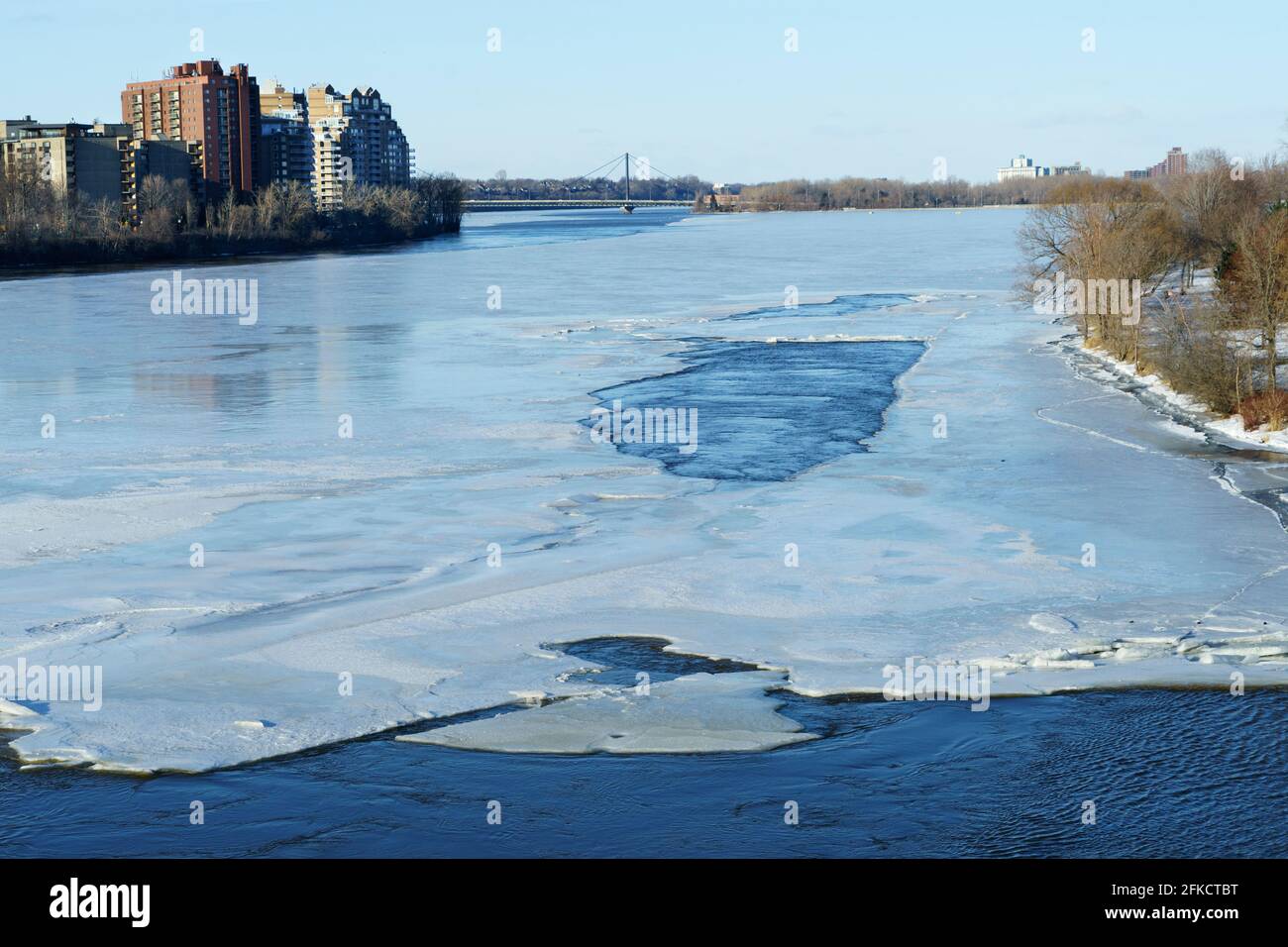Seen from the Viau bridge, ice is thawing on Riviere des Prairies at the beginning of spring. Montreal on the right, Laval on the left.Quebec, Canada. Stock Photo