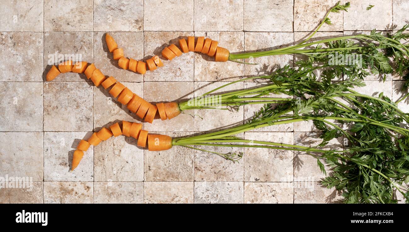 Karotte Roots Bunch of fresh carrot roots with green leaves on stone tales of earth ...