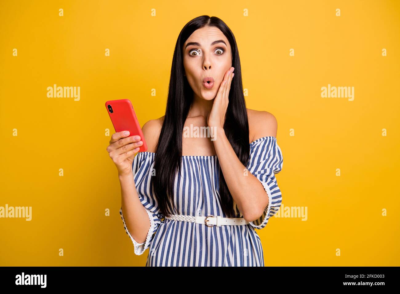 Photo of sweet impressed woman dressed off-shoulders outfit reading modern gadget arm cheek isolated yellow color background Stock Photo