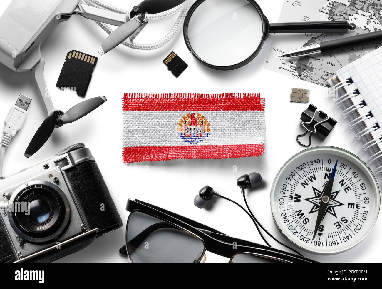 Flag of French Polynesia and travel accessories on a white background. Stock Photo