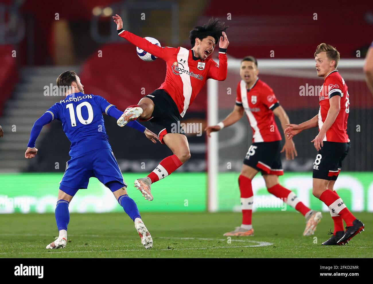 Southampton's Takumi Minamino falls to the ground as Leicester City's James Maddison looks on during the Premier League match at St. Mary's Stadium, Southampton. Picture date: Friday April 30, 2021. Stock Photo