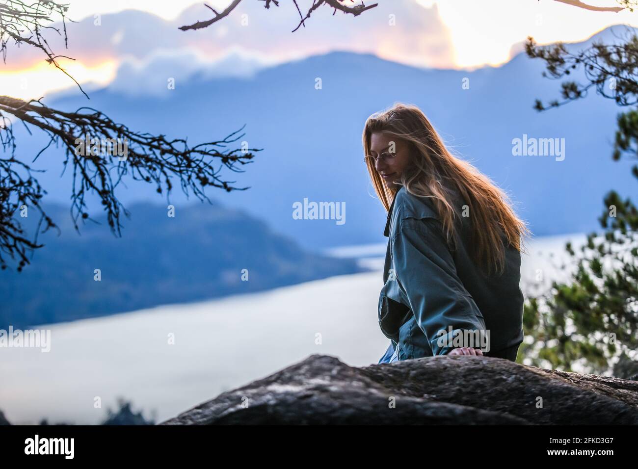 Canada, British Columbia, Squamish, Young woman sitting on rock Stock Photo