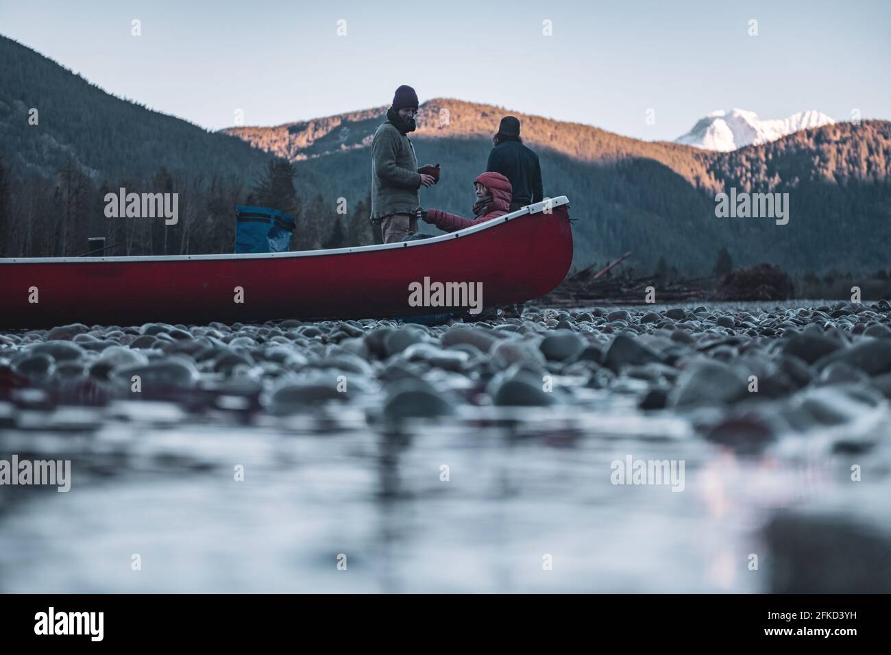 Canada, British Columbia, Friends with canoe resting at Squamish River Stock Photo