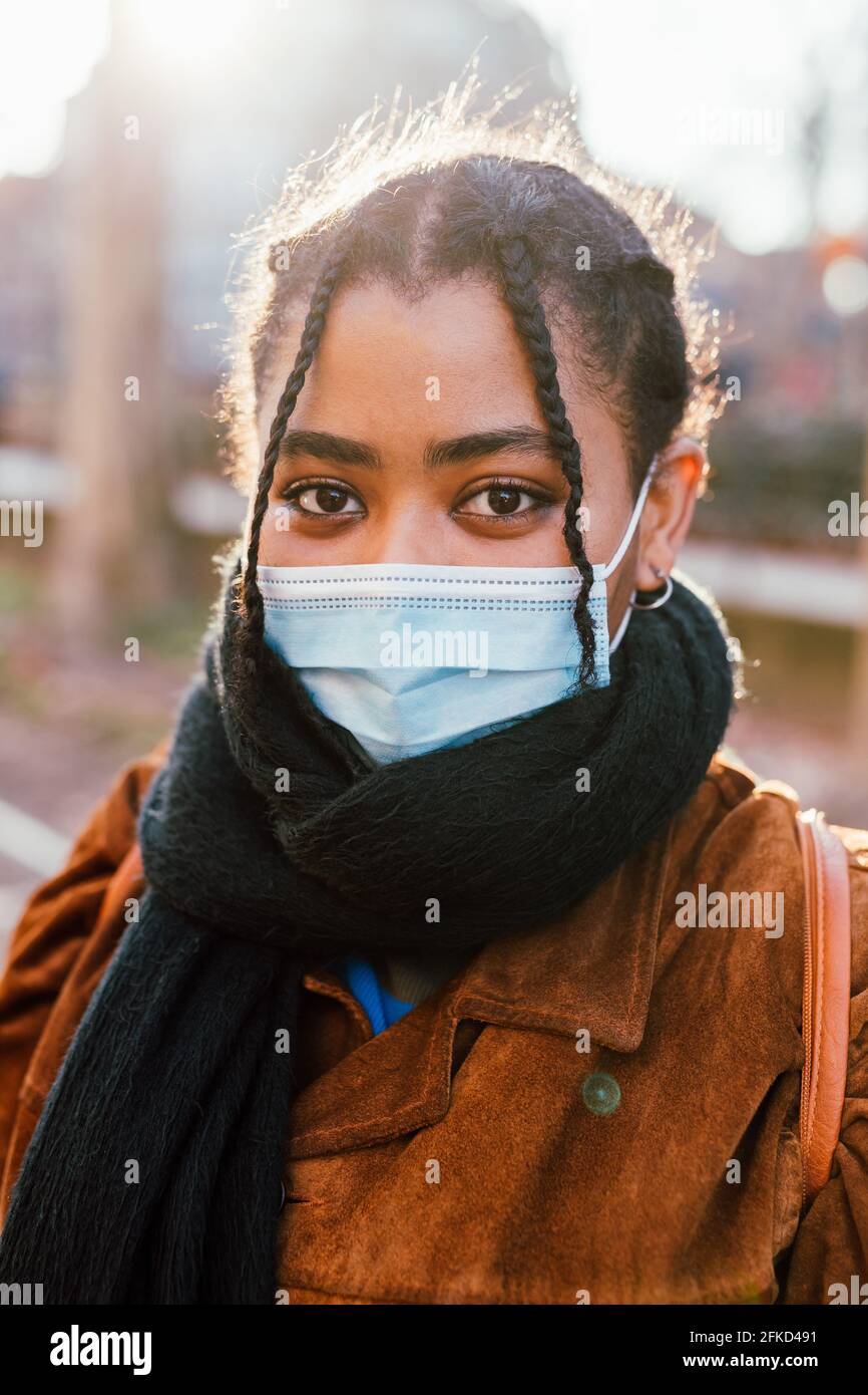 Portrait of young woman in face mask outdoors Stock Photo - Alamy