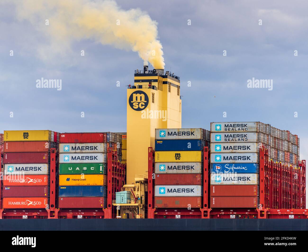Nitrogen Oxide Pollution from shipping - Ship Funnel Exhaust - Pollution from Container Ships -  NOx emissions Nitrogen Oxide rich yellow funnel smoke Stock Photo