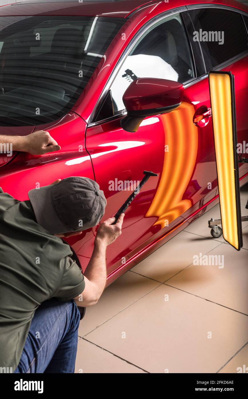 The technician removes dents on the car using the method without