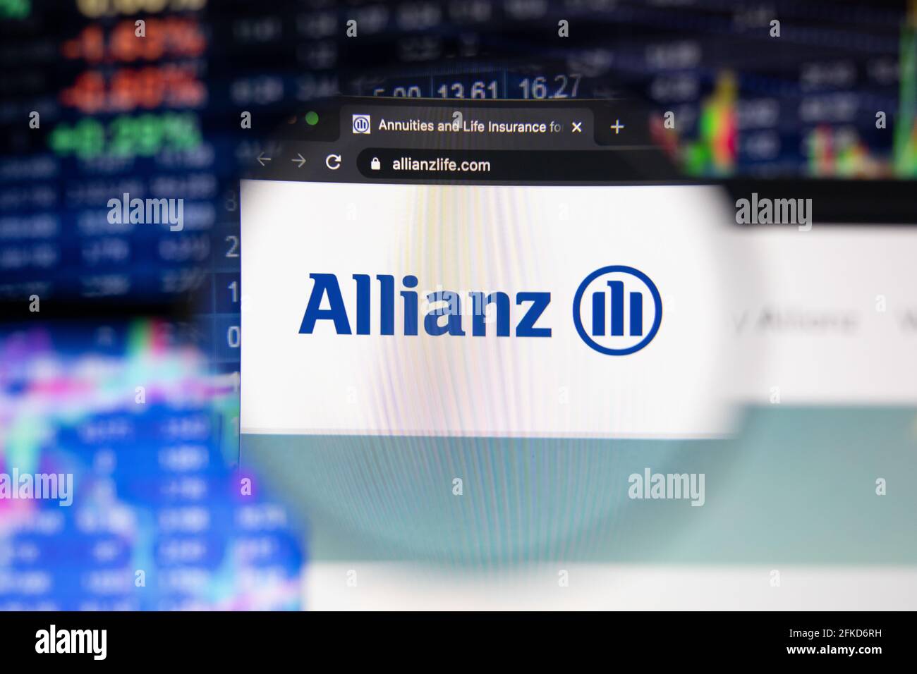 Allianz company logo on a website with blurry stock market developments in the background, seen on a computer screen through a magnifying glass Stock Photo