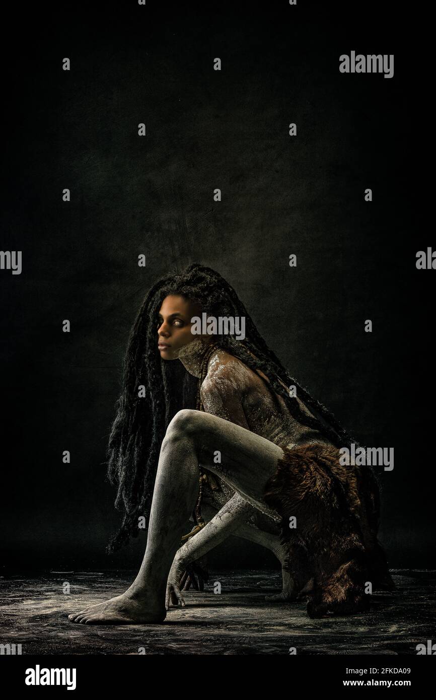 Young tribal woman covered in clay, wearing dreadlocks and bone necklaces Stock Photo