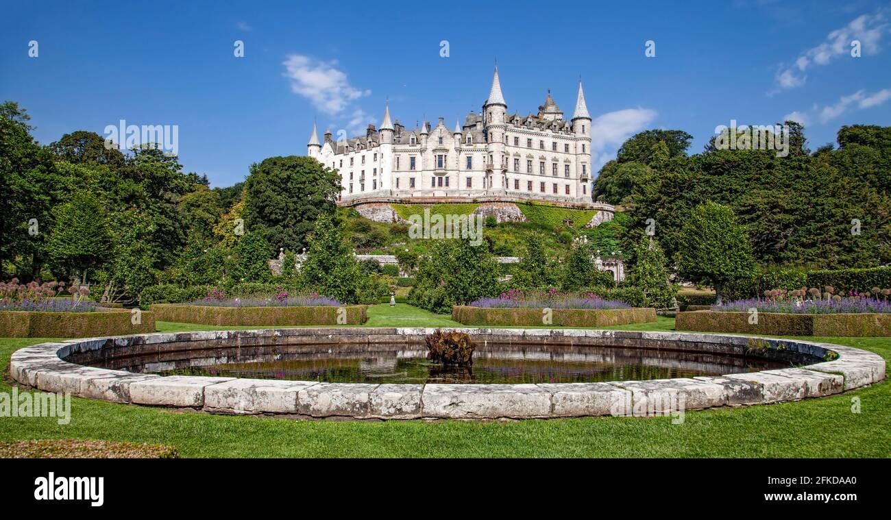A castle with a clock tower in front of a building Stock Photo - Alamy