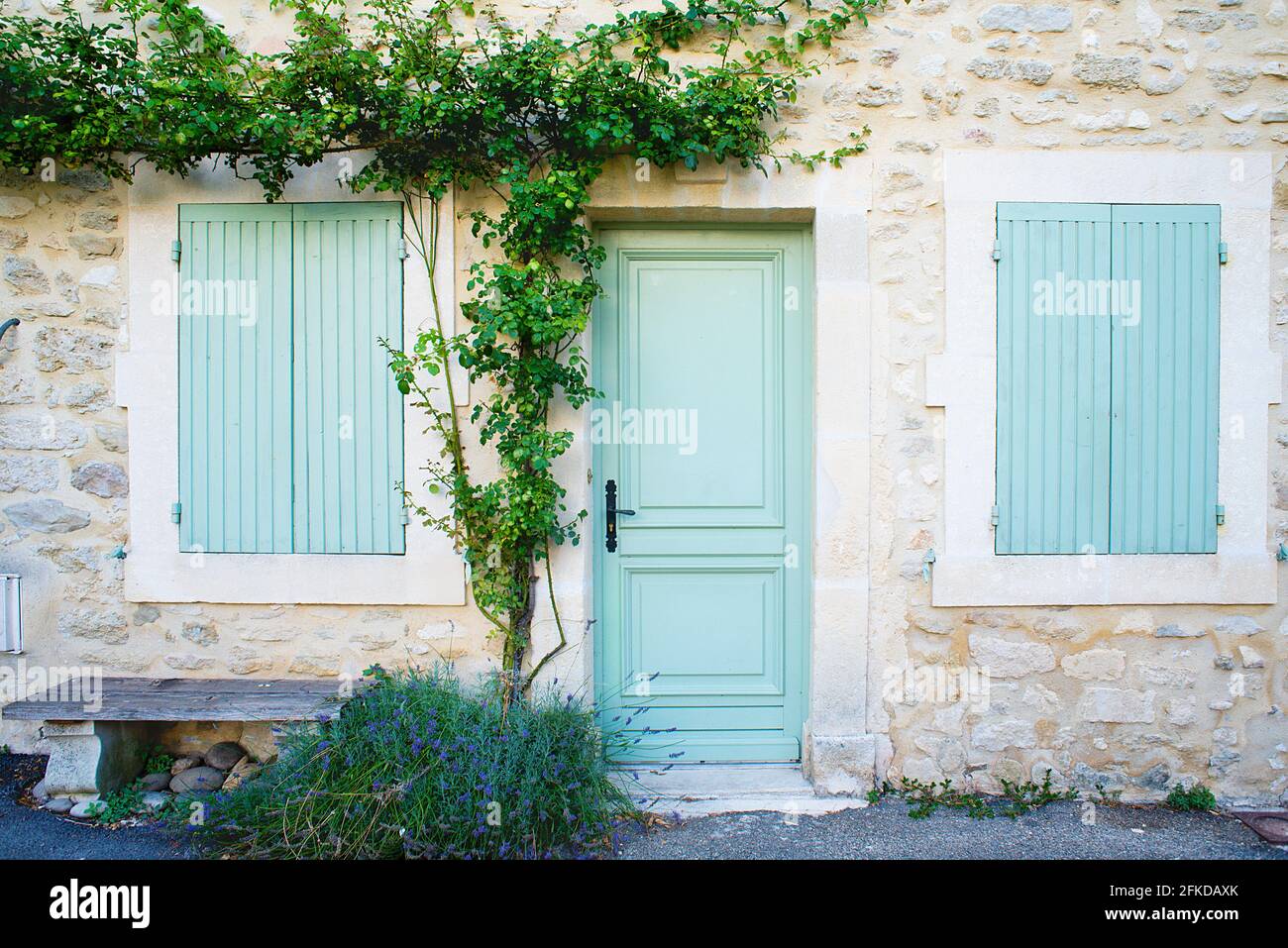 Facade of a Provencal house with wooden shutters and tree Stock Photo