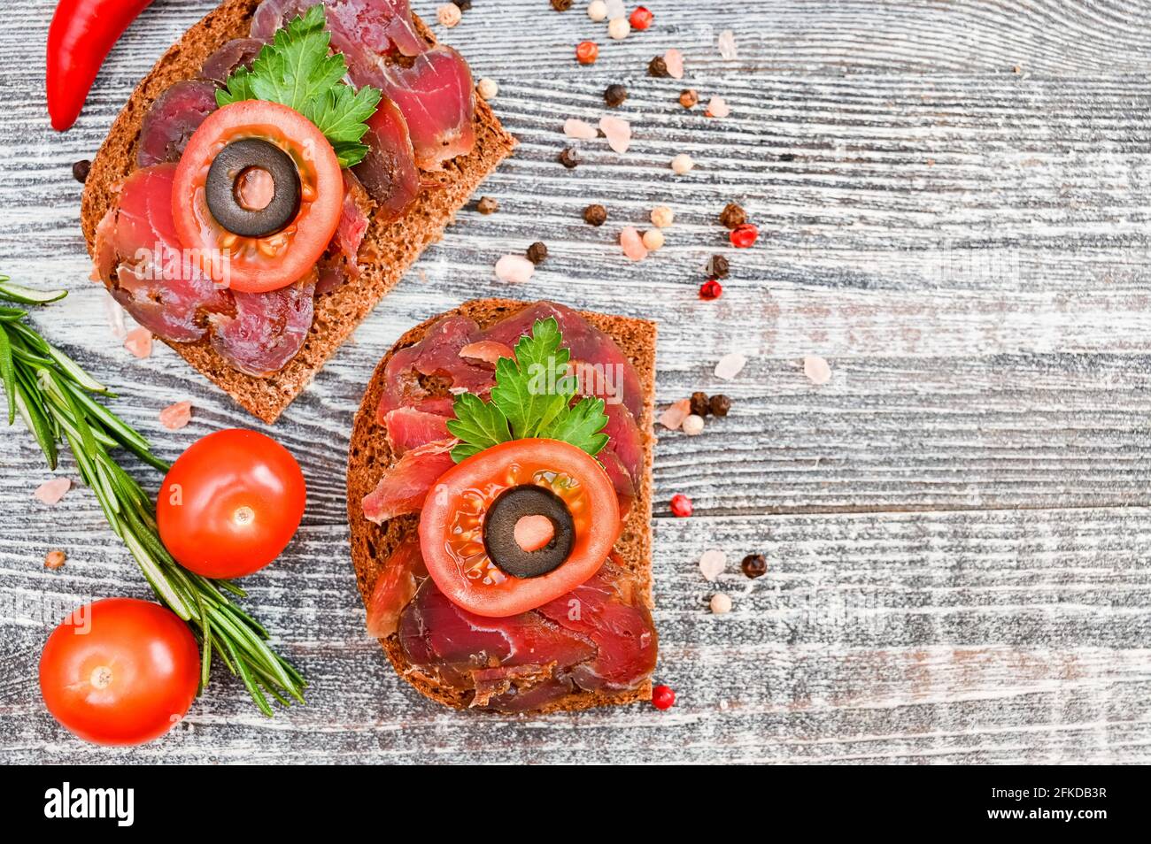 Closeup top view of sliced drycured venison on the wooden gray table