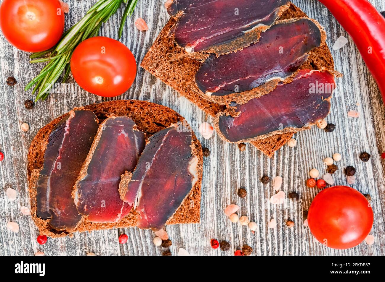 Closeup top view of sliced drycured venison on the wooden gray table