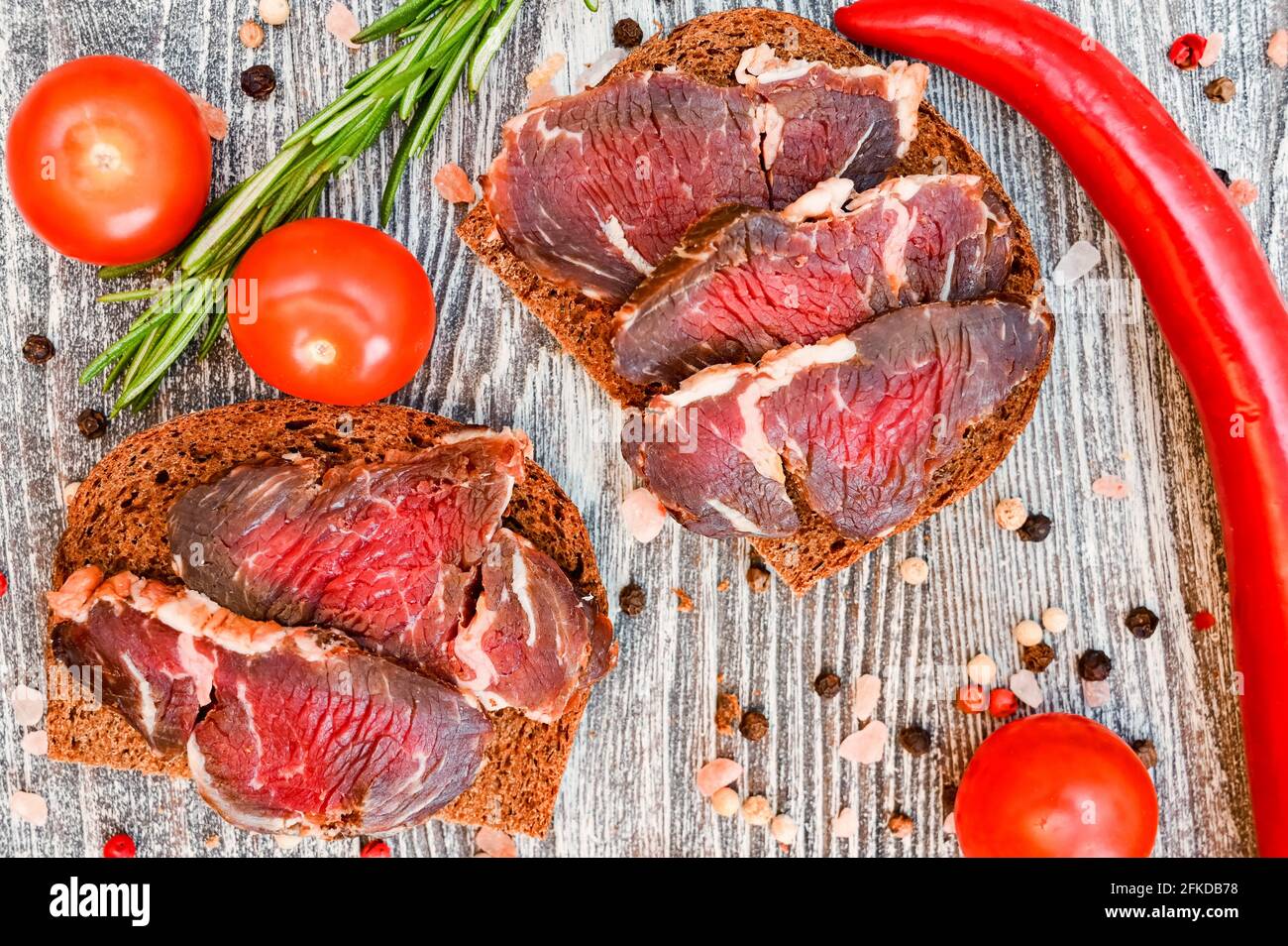 Closeup top view of sliced drycured venison on the wooden gray table