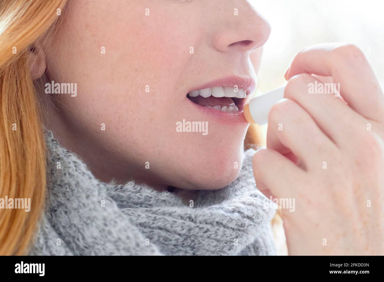 Woman applying lip balm Stock Photo