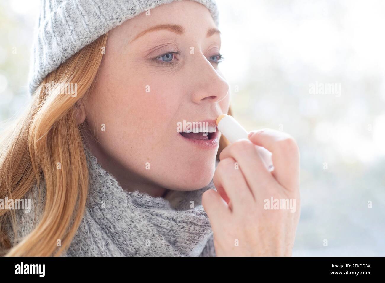 Woman applying lip balm Stock Photo