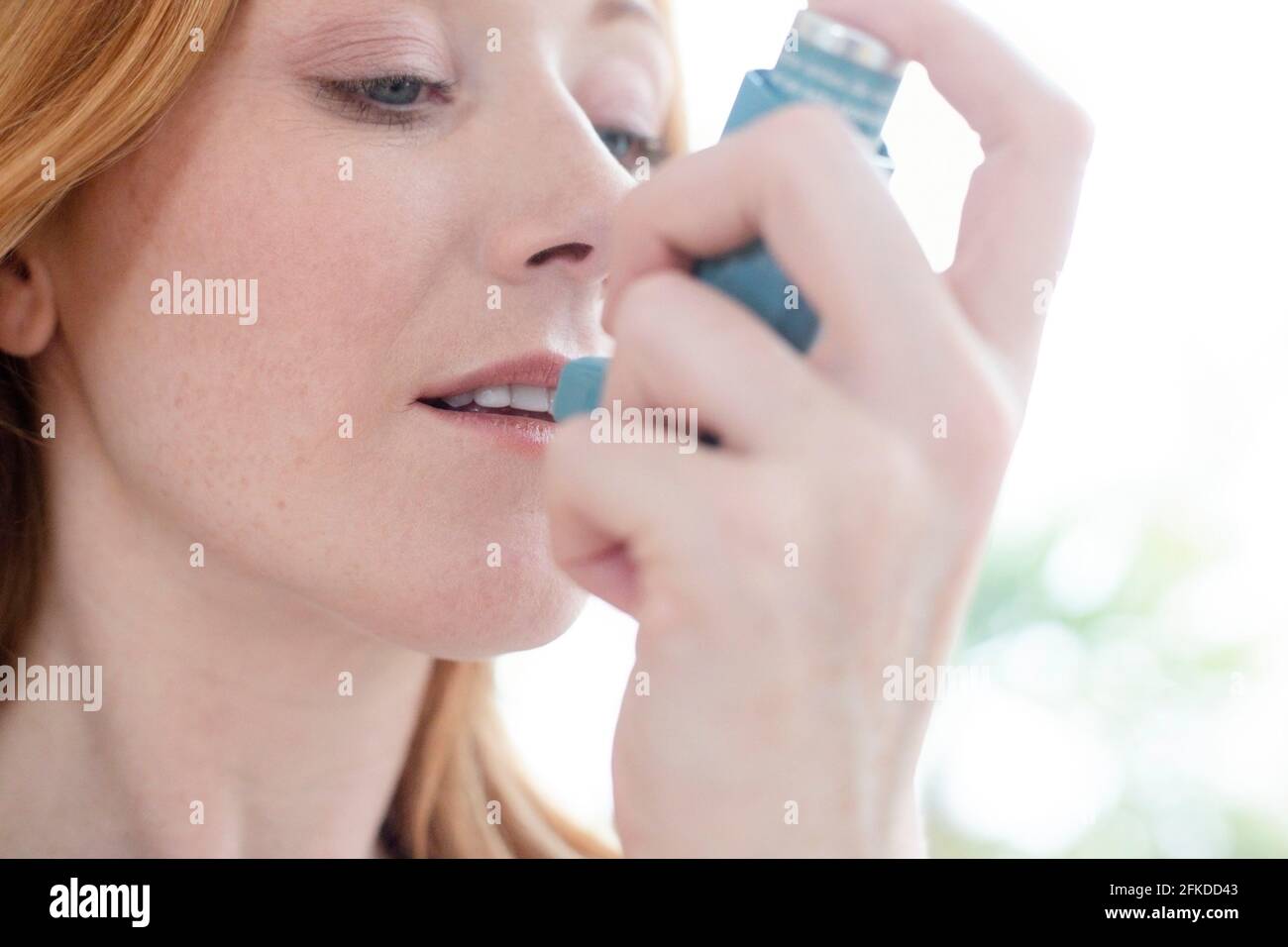 Woman using inhaler Stock Photo