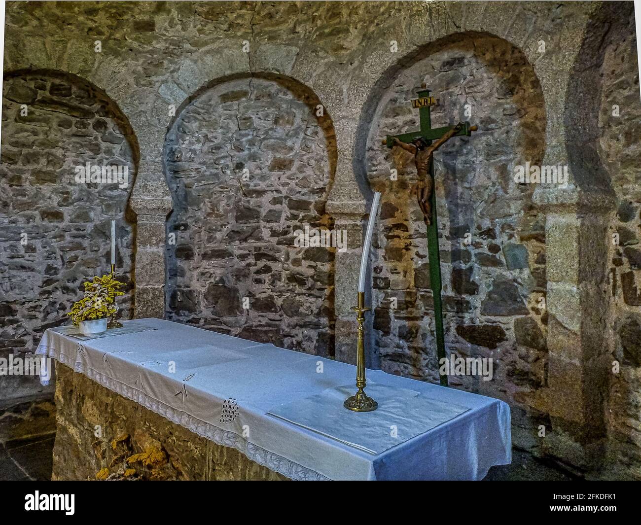 altar with a leaning candle in the ancient mozarabic Church of Santo Tomás de las Ollas, Ponferrada, Spain, July 17, 2010 Stock Photo