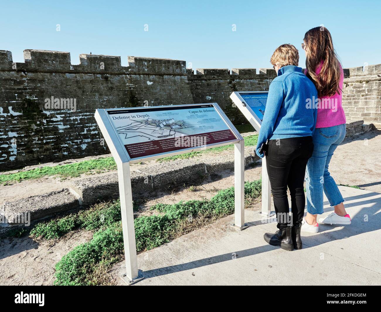 Women tourists at the Castillo de San Marcos a large Spanish stone fortress or fort built in the 1600's guards the port in St. Augustine Florida, USA. Stock Photo