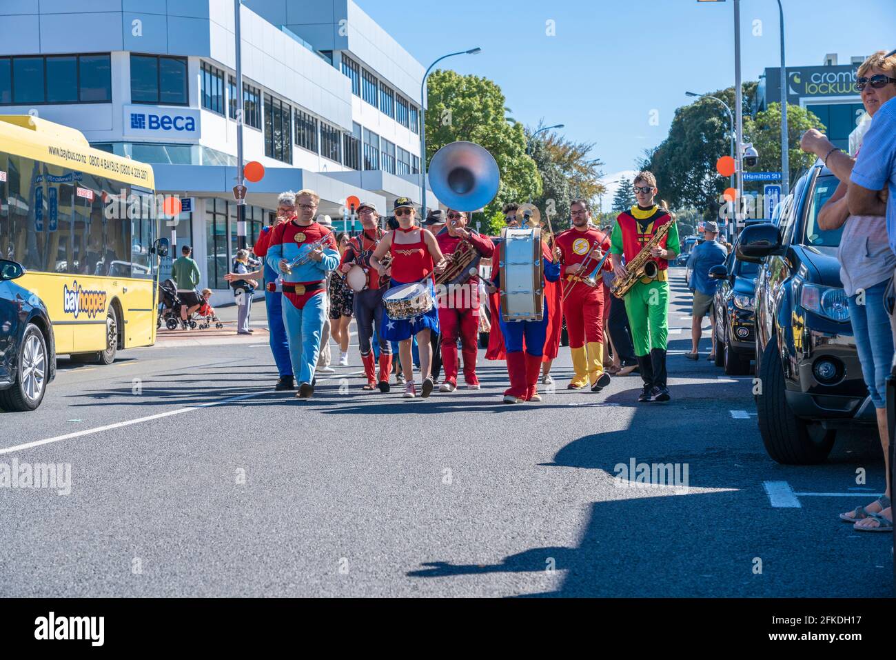 Tauranga New Zealand - April 3 2021; Superhero Band marching along city street past buildings and people during National Jazz Festival Stock Photo
