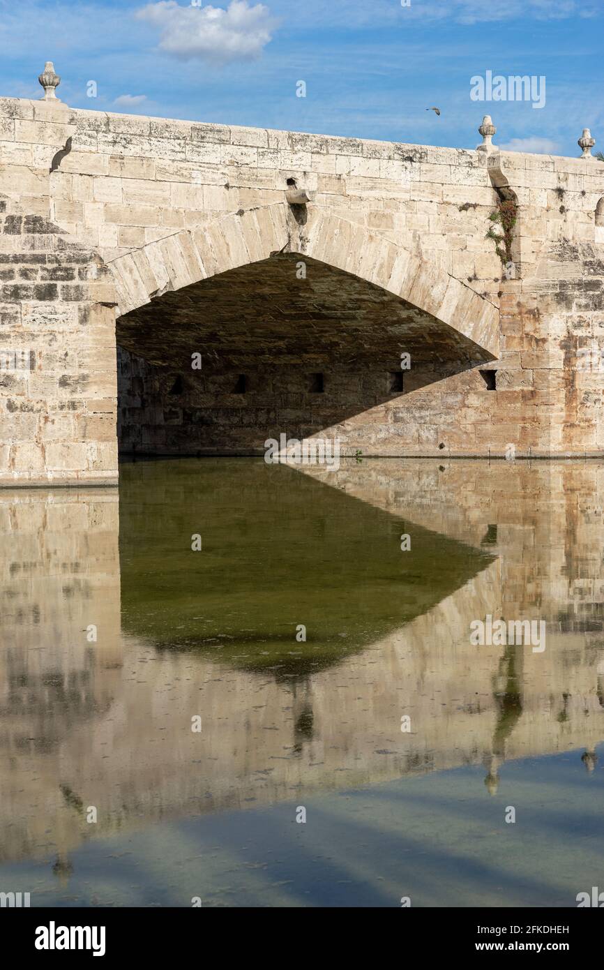 Reflections of an ancient stone bridge across old river bed. Puente del Mar, Turia river, Valencia, Spain Stock Photo