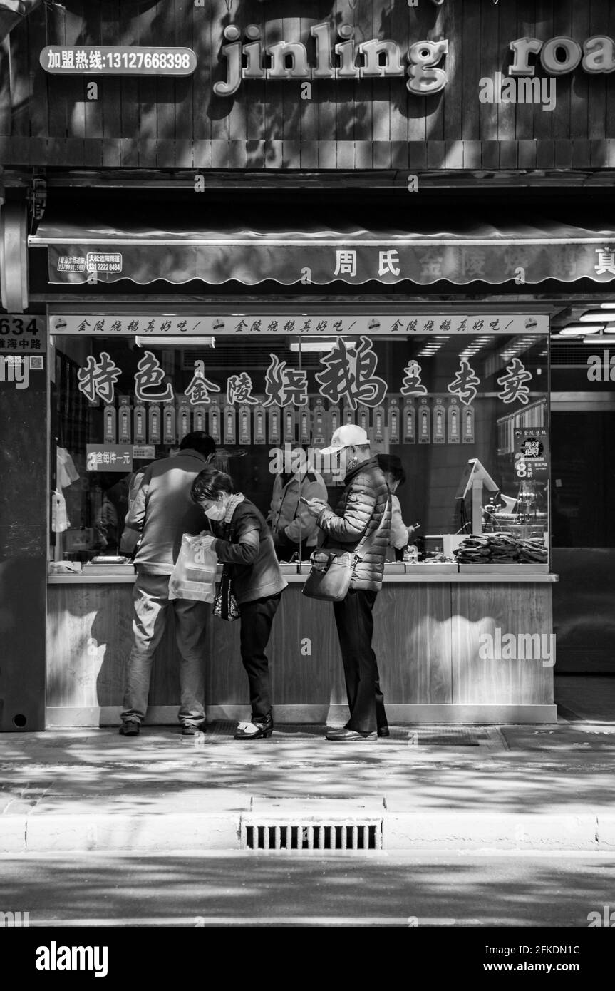 People buying roast goose from the Jinling Roast Goose store on Huai Hai Zhong lu in central Shanghai, China. Stock Photo
