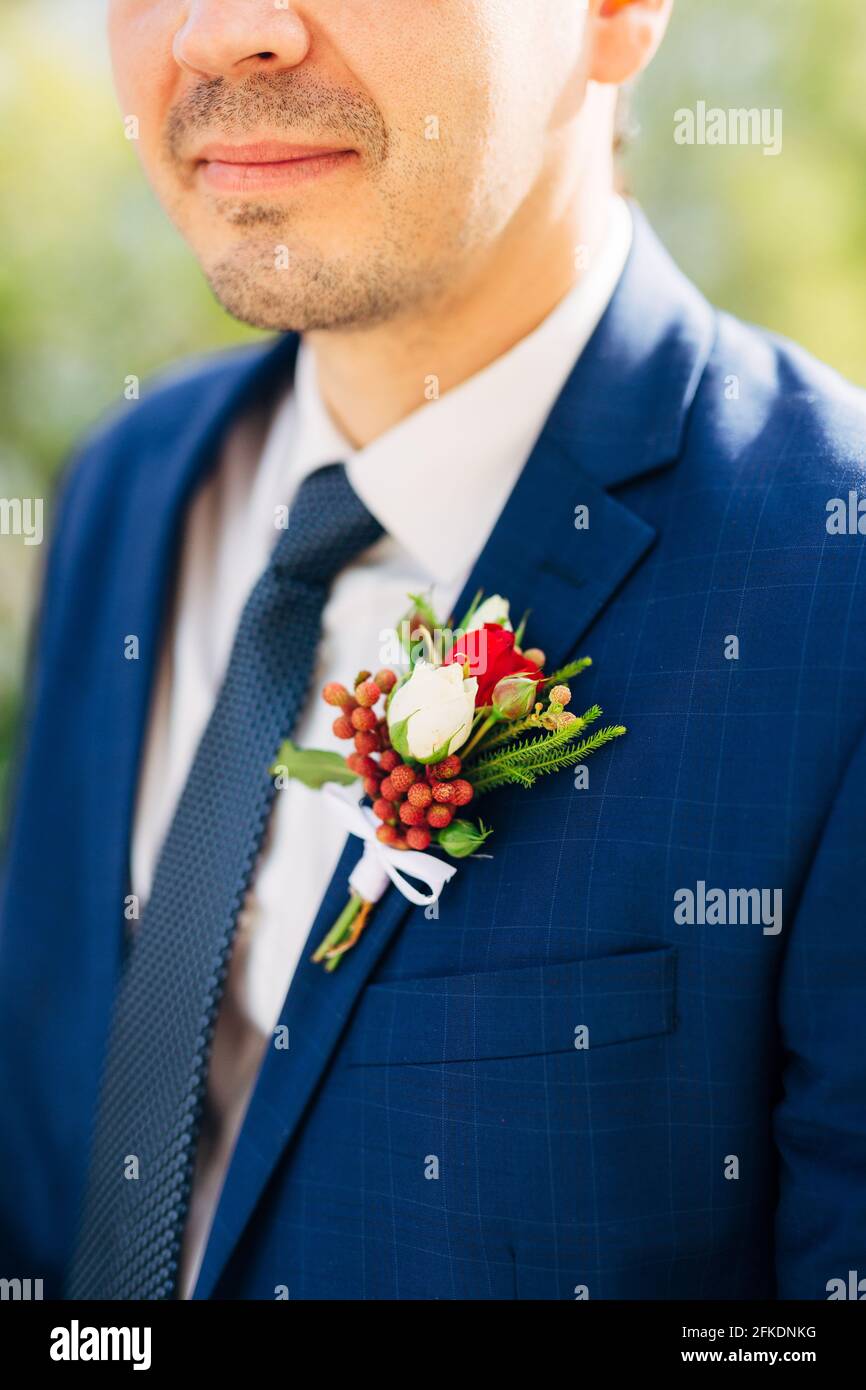 Groom in a blue jacket, tie and white shirt with a boutonniere on the lapel  Stock Photo - Alamy
