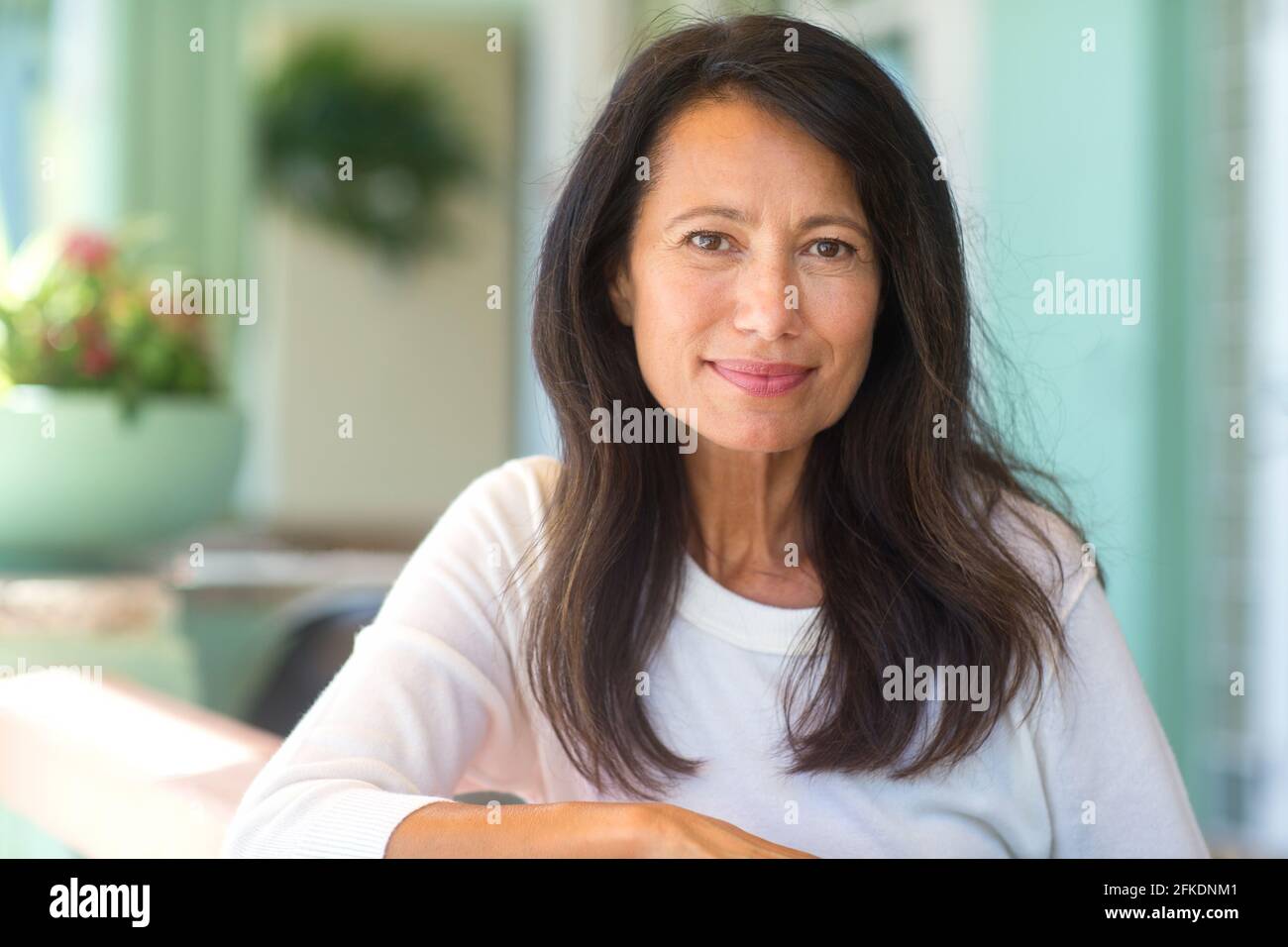 Portrait of a beautiful mature woman sitting on the sofa Stock Photo ...