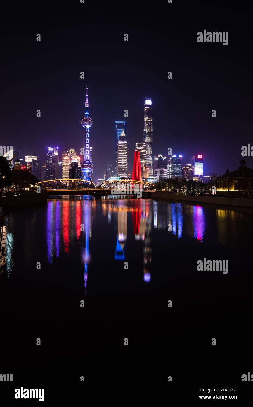 Shanghai Pudong skyline at night with colourful skyscrapers and reflections in water Stock Photo