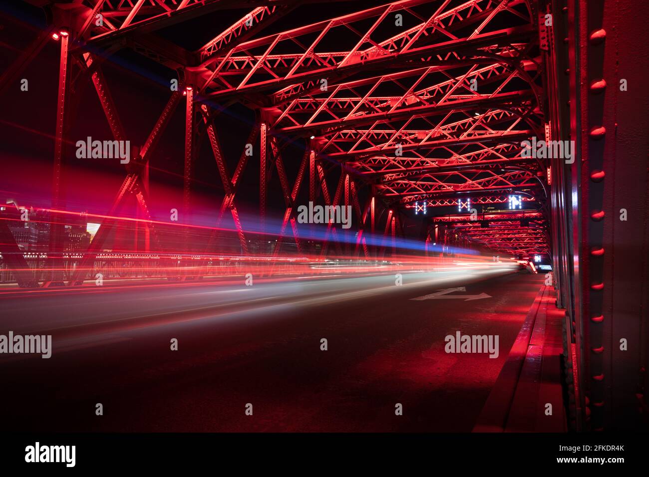 Dramatic long exposure iron bridge in Shanghai with light of passing traffic at night Stock Photo