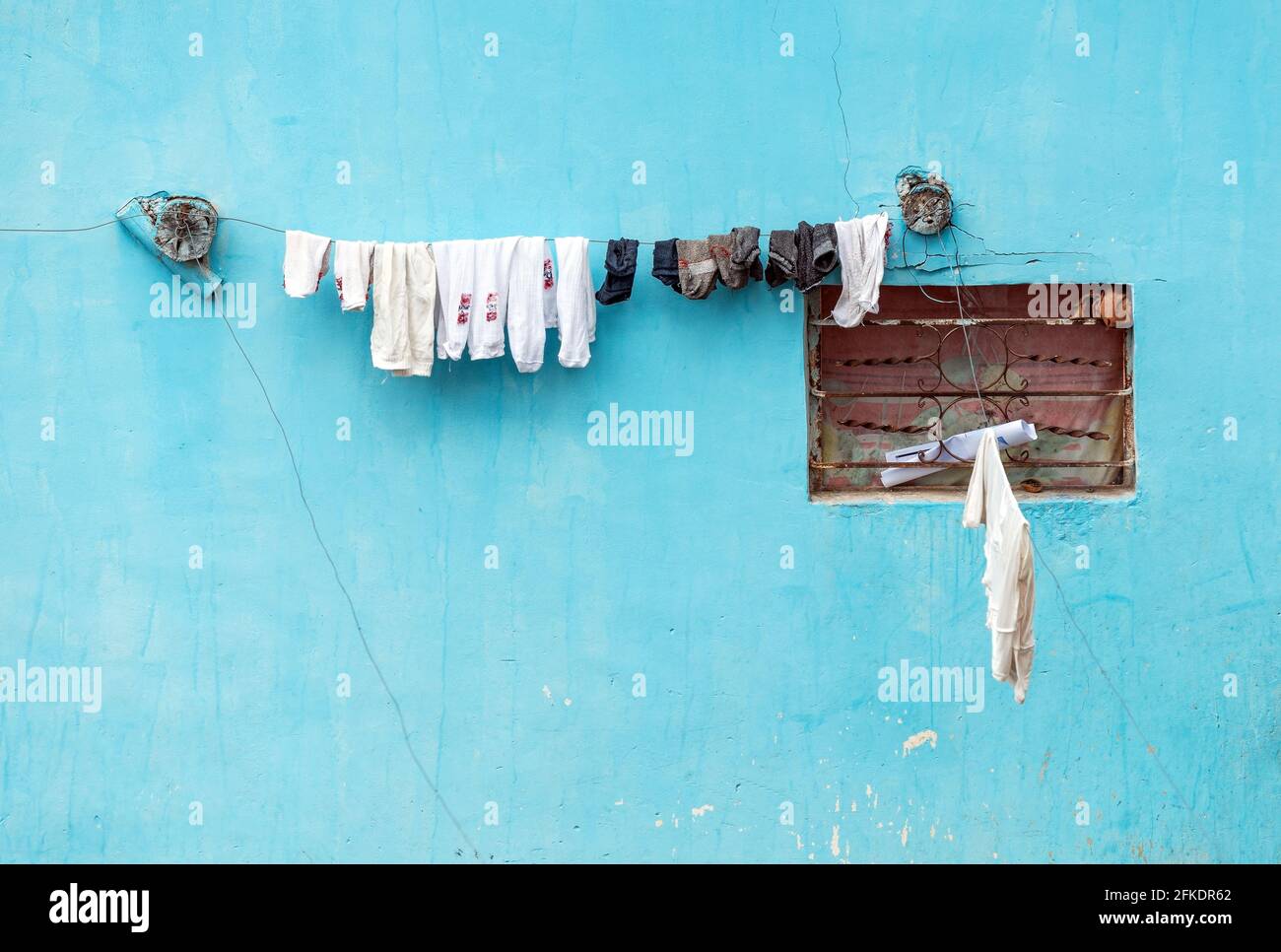 Turquoise facade with socks drying on iron wire, Otavalo, Ecuador. Stock Photo