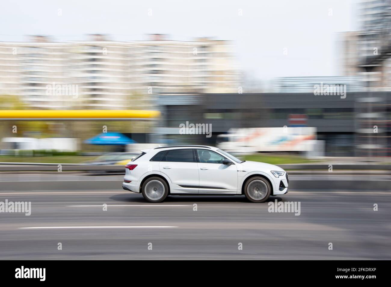 Ukraine, Kyiv - 20 April 2021: White Audi e-tron car moving on the street. Editorial Stock Photo