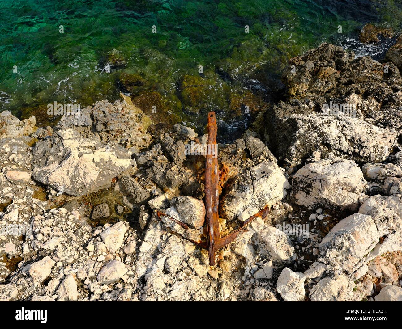 VERTICAL AERIAL VIEW with a 6-meter-high mast. Rusted anchor embedded in a limestone shore. Nice, French Riviera, Alpes-Maritimes, France. Stock Photo