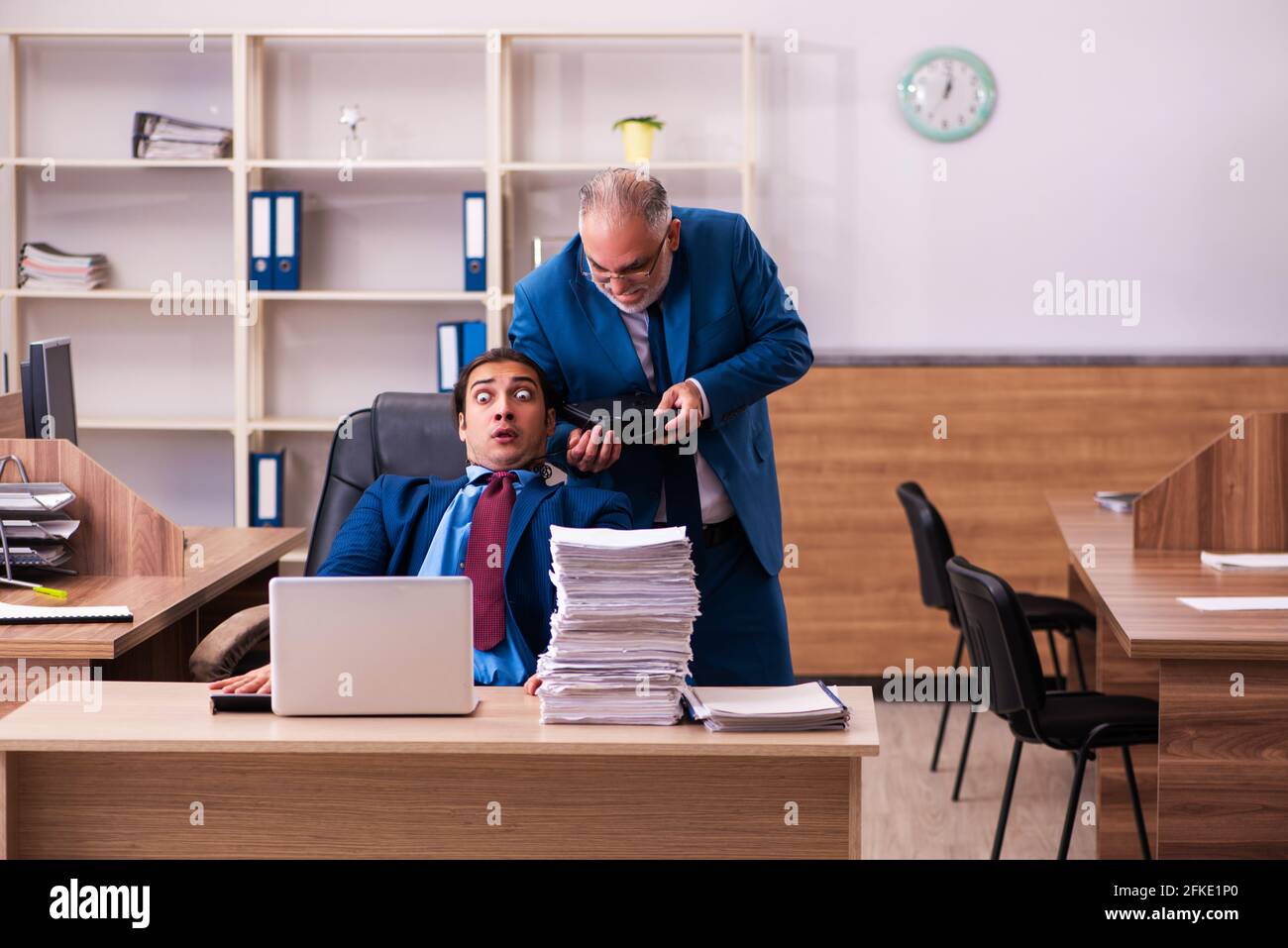 Old boss and his young male assistant in bullying concept Stock Photo ...