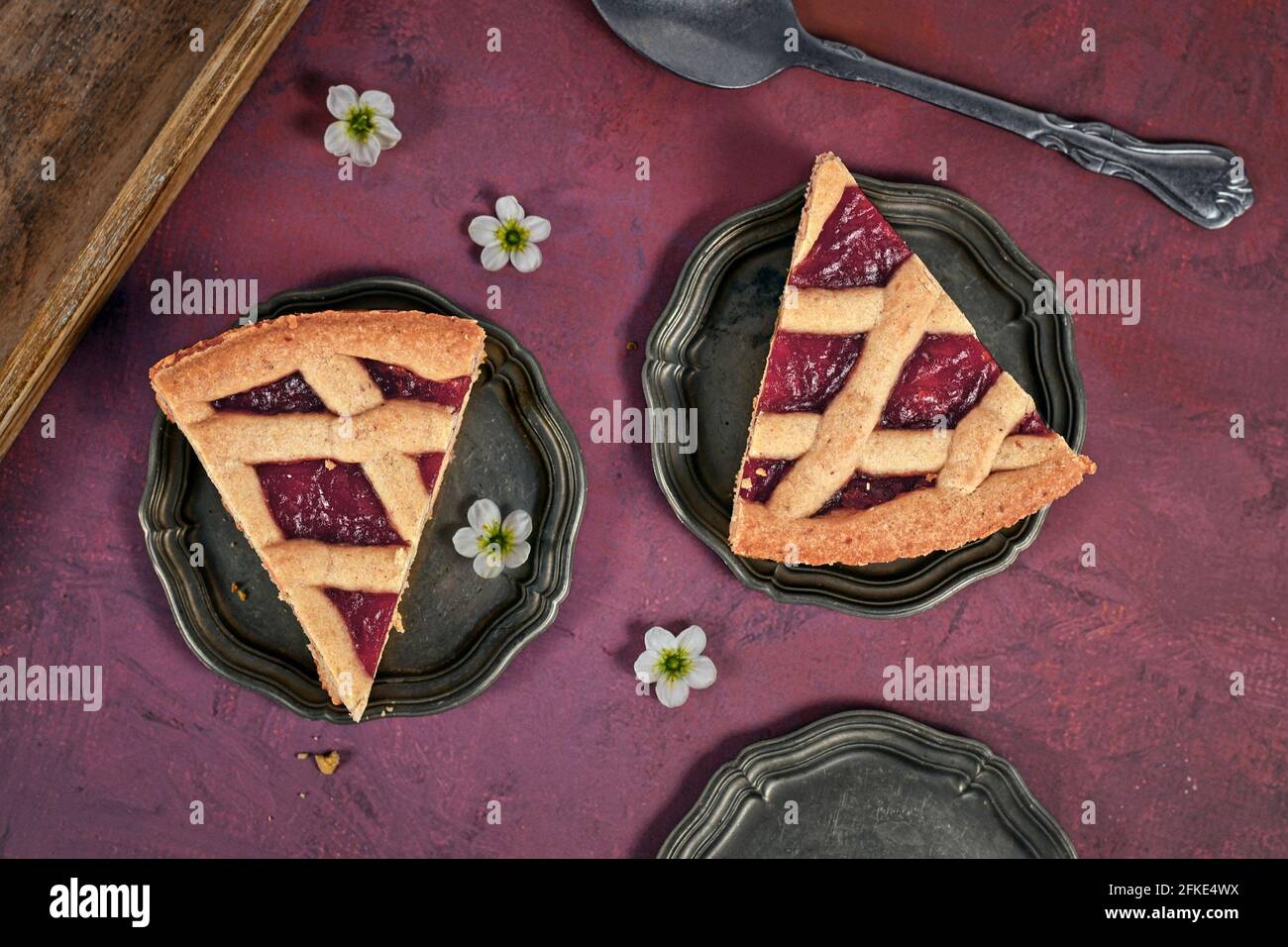 Slices of pie called 'Linzer Torte', a traditional Austrian shortcake pastry topped with fruit preserves and sliced nuts with lattice design Stock Photo
