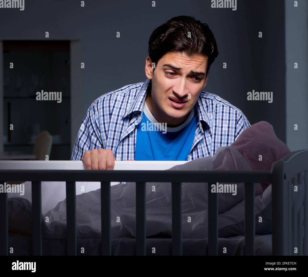 The young father under stress due to baby crying at night Stock Photo