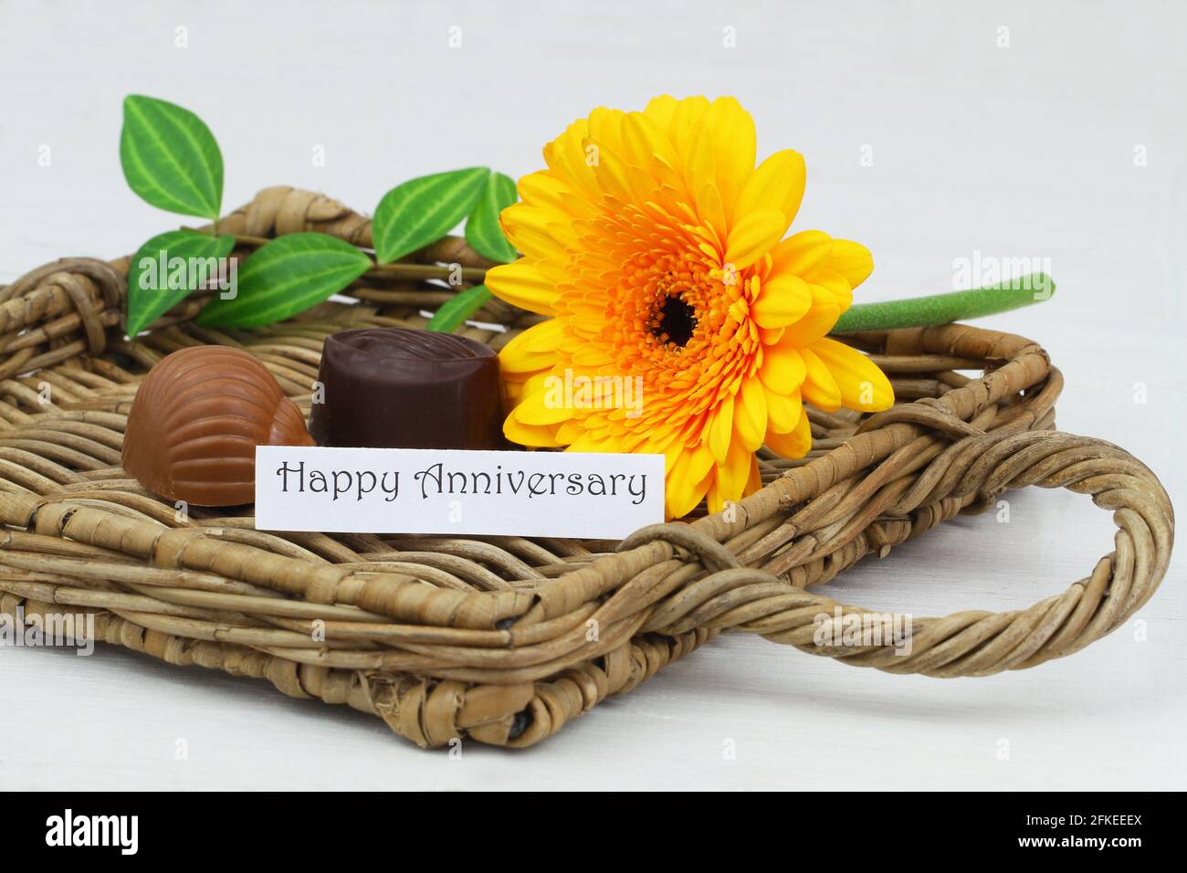 Happy Anniversary card with yellow gerbera daisy and milky chocolates Stock Photo