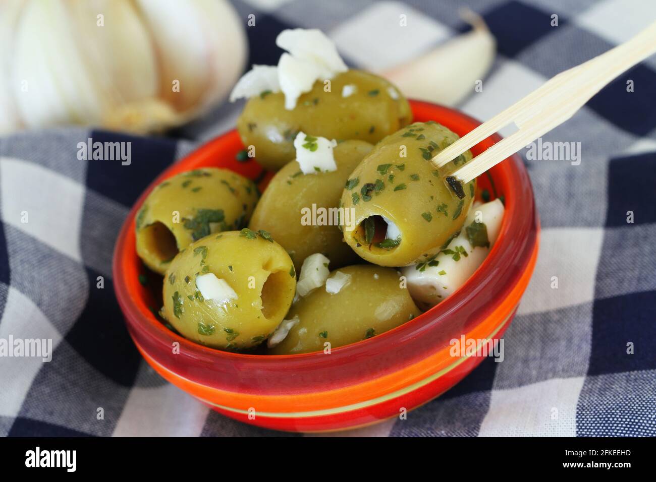 Green olives with feta cheese and red peppers in transparent plastic box Stock Photo