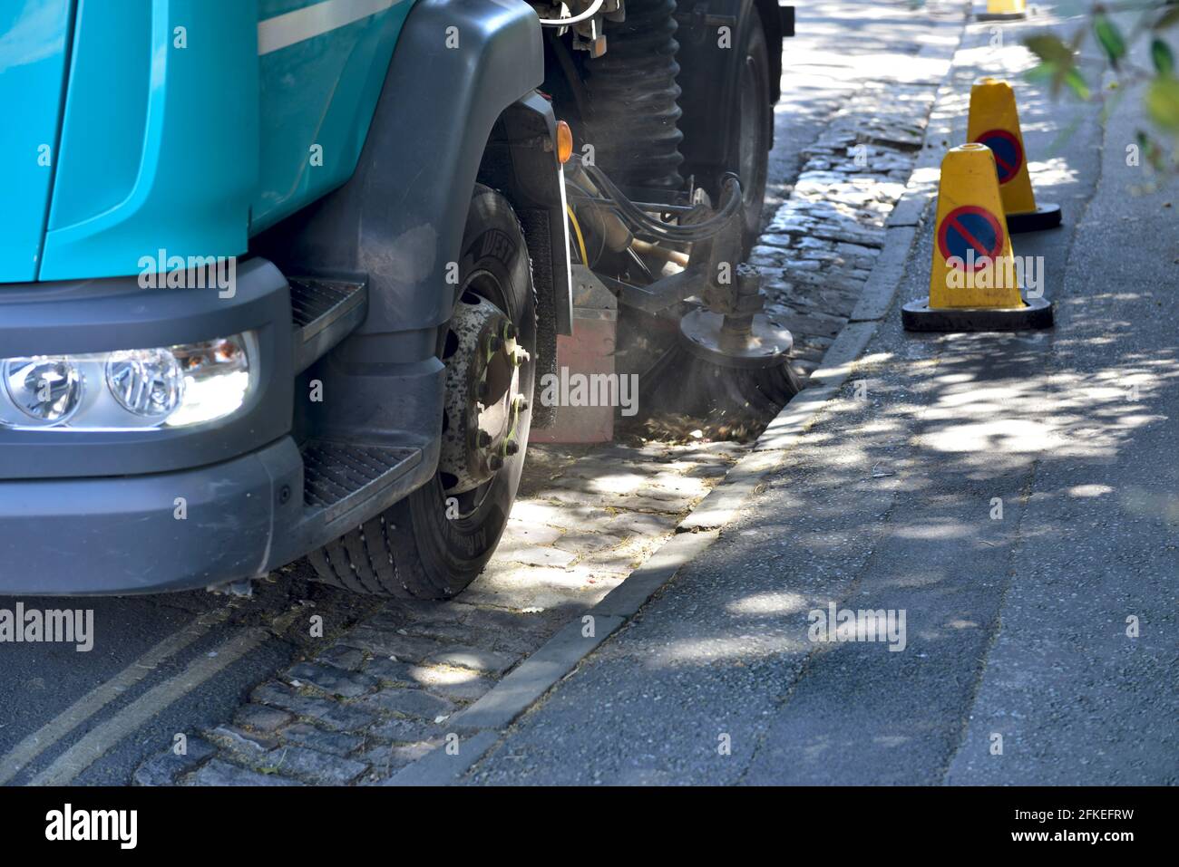 Street sweeping machine cleaning gully in road Stock Photo