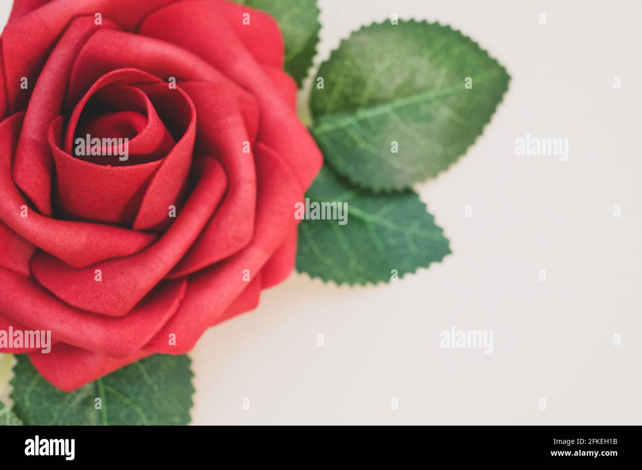Artificial red rose isolated on light background Stock Photo Alamy