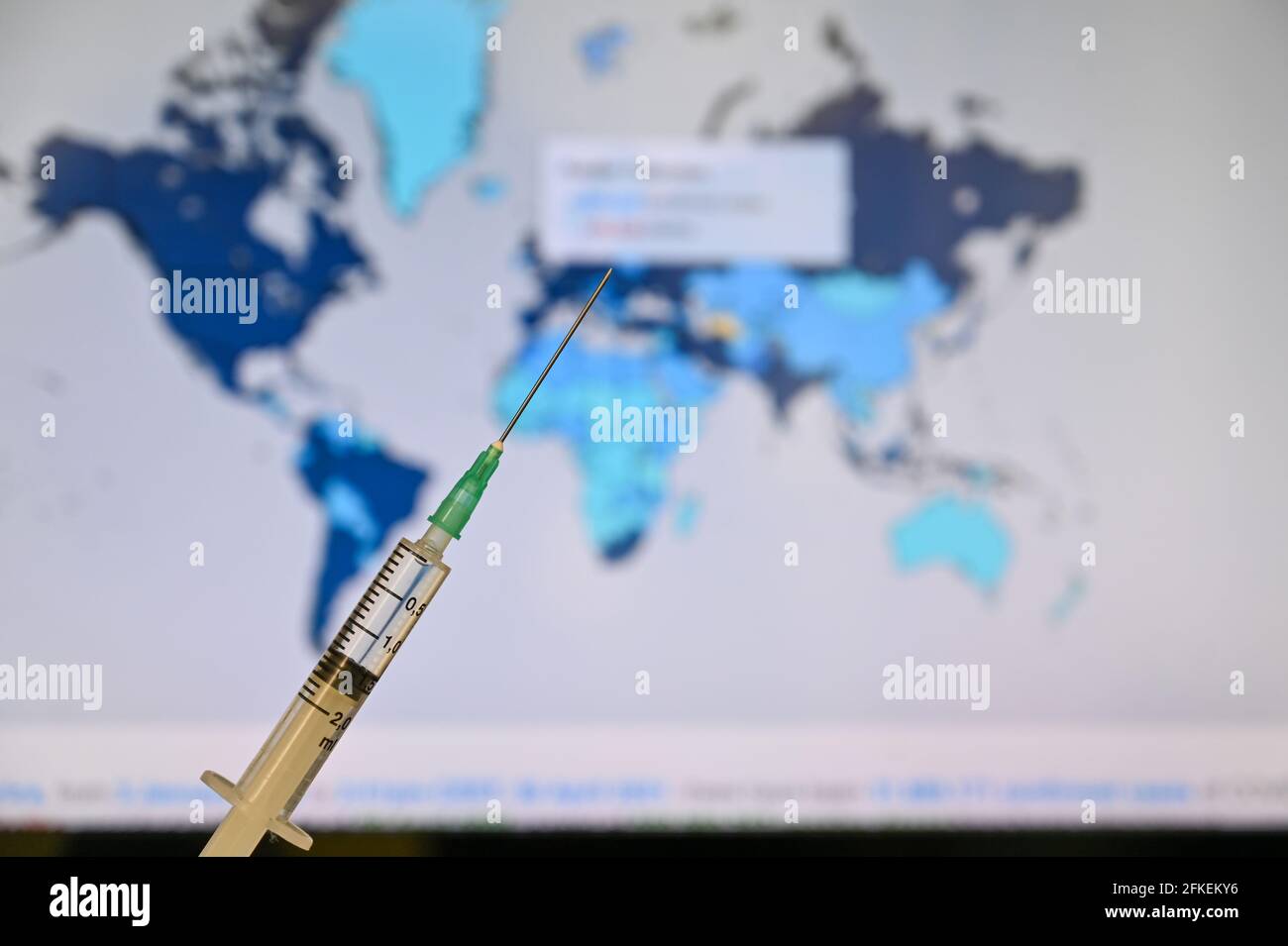 Syringe with world map background. Covid 19 vaccine is popular trend of world agenda Stock Photo