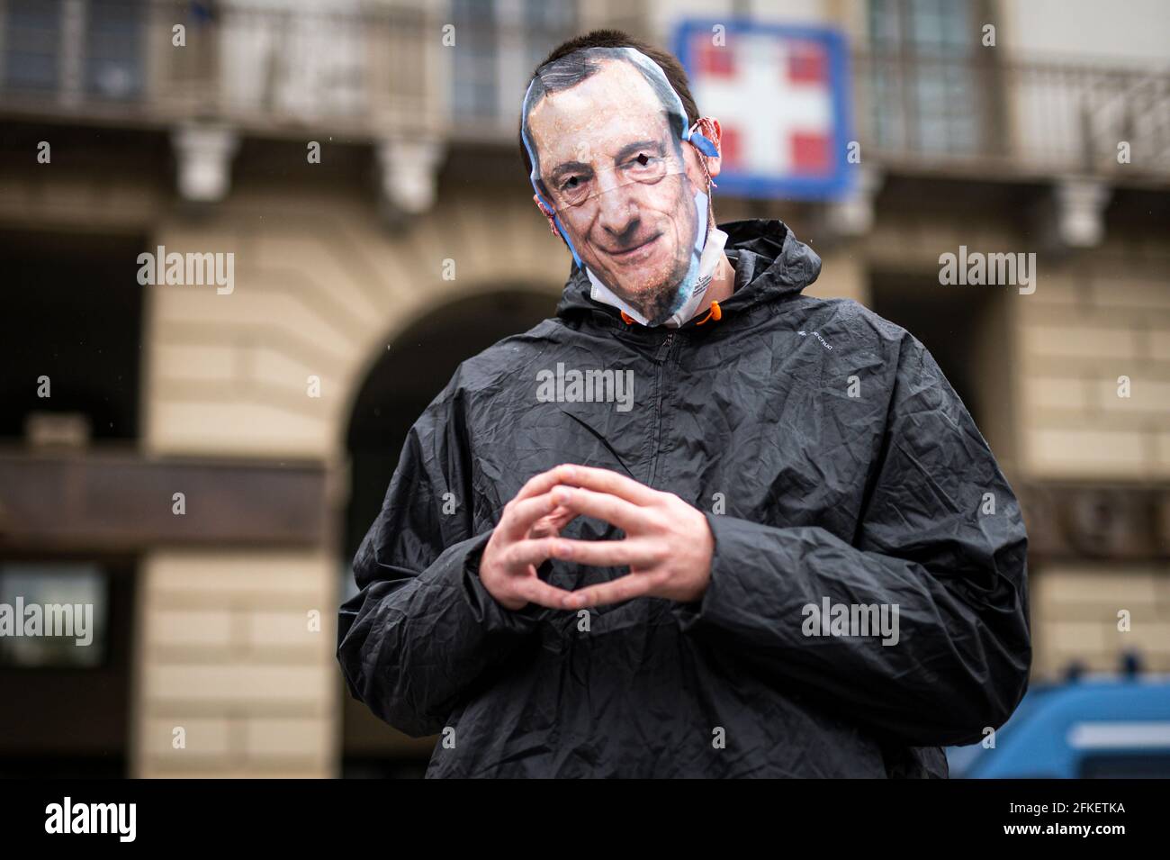 Turin, Italy. 01 May 2021. A demonstrator wearing a mask depicting Italian Prime Minister Mario Draghi gestures during a May Day rally (also known as International Workers' Day or Labour Day). May Day occurs every year on 1 May and it is used to mark the fight for workers' rights across the world . Credit: Nicolò Campo/Alamy Live News Stock Photo