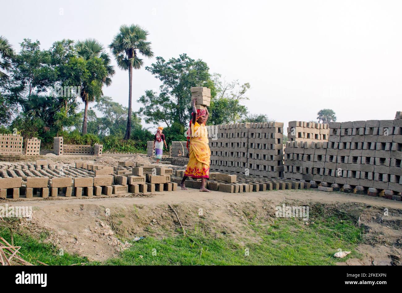 Picture of a brick kiln in the remote Hooghly district. Adult workers work hard to arrange the raw bricks in the kiln to baked. Stock Photo
