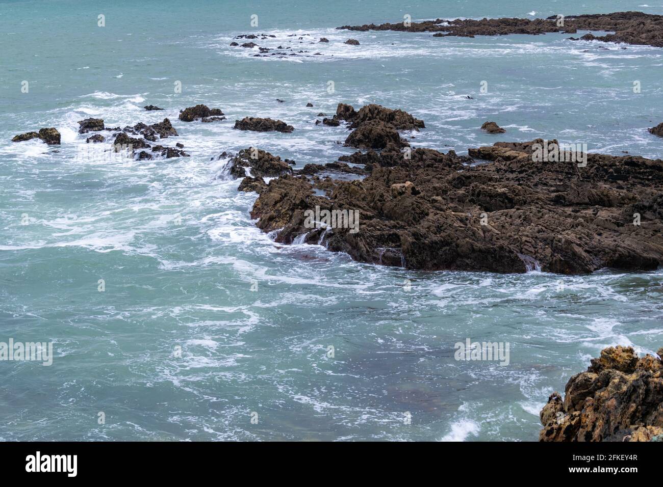 Beautiful shot of seawater breaking on the rocky coast Stock Photo - Alamy