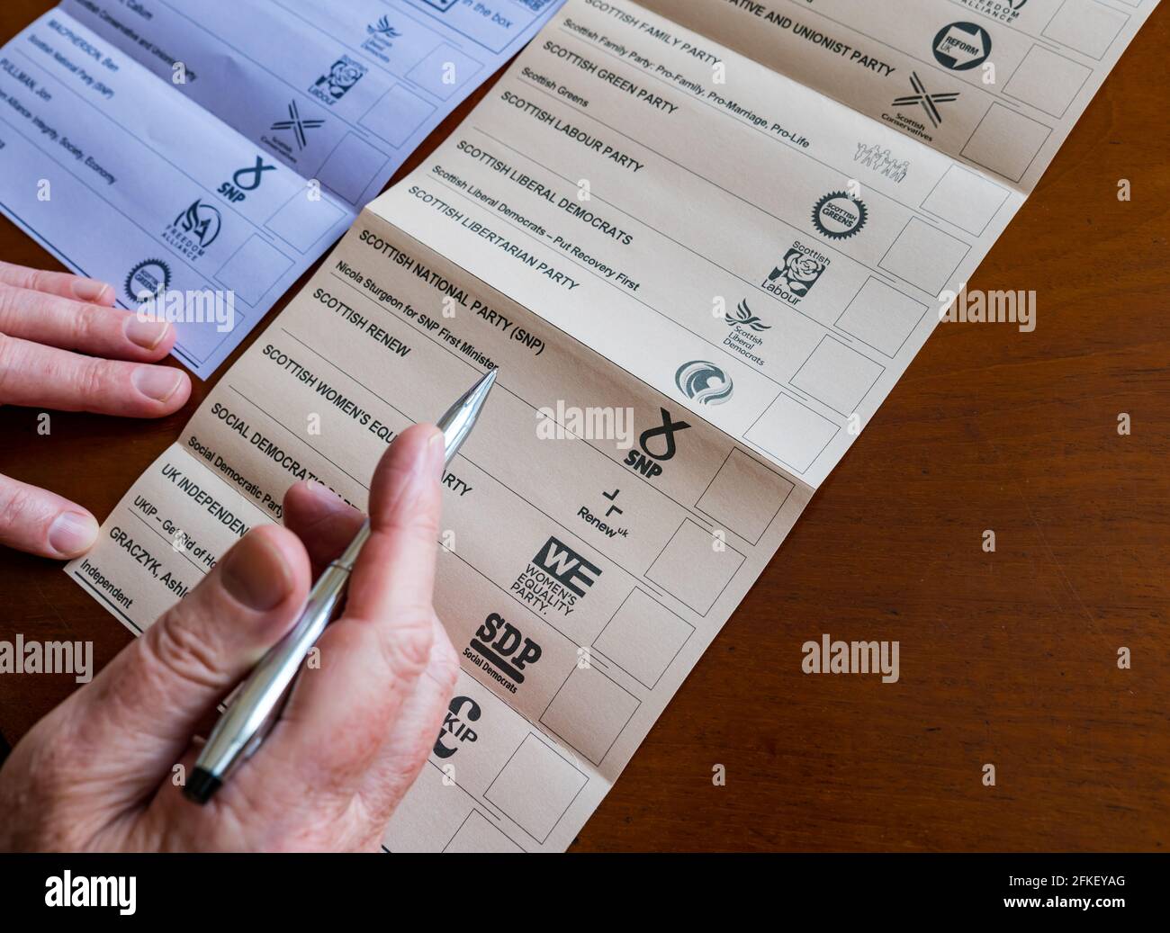 Man voting on ballot paper in 2021 Scottish parliament election for Edinburgh North & Leith constituency & Regional candidates list, Scotland, UK Stock Photo