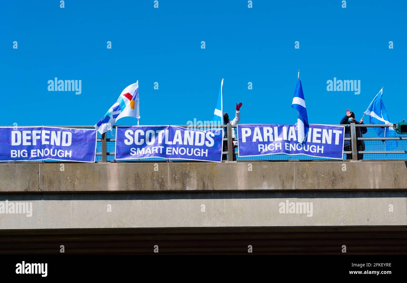 Lamberton, Scottish Borders, Scotland, UK. 1 May 2021. Pro Scottish Independence supporters attach flags and signs to bridges crossing the A1 highway and wave to passing motorists today. Iain Masterton/Alamy Live News Stock Photo