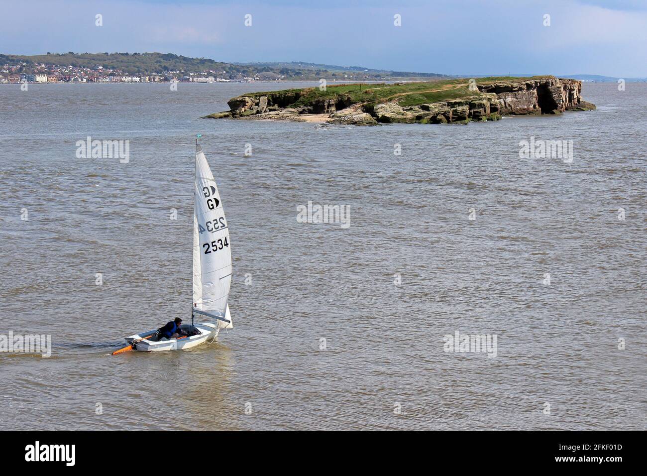 Sailor In GP14 Dingy Navigates From Hilbre Island At High Tide Towards Middle Eye, Dee Estuary, Wirral, UK Stock Photo